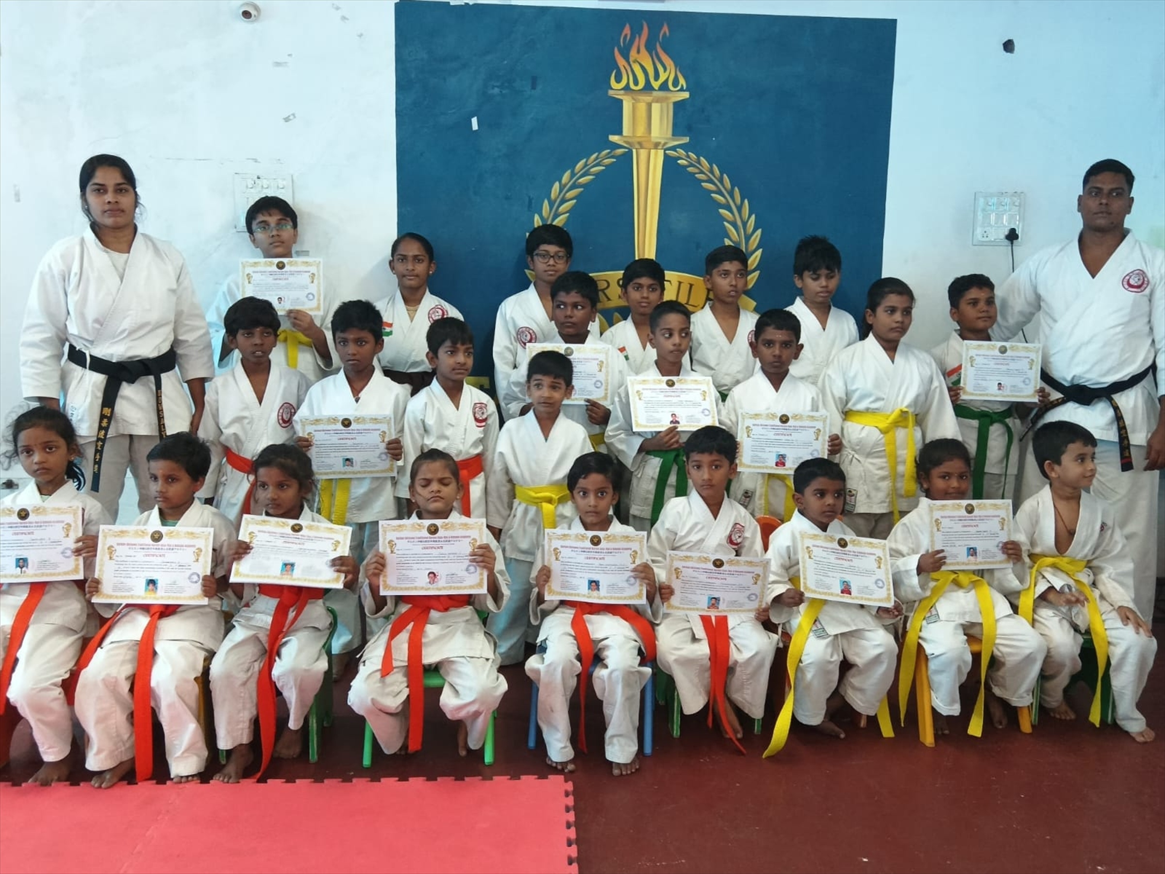 Children and instructors together after the December 2025 karate belt grading with certificates