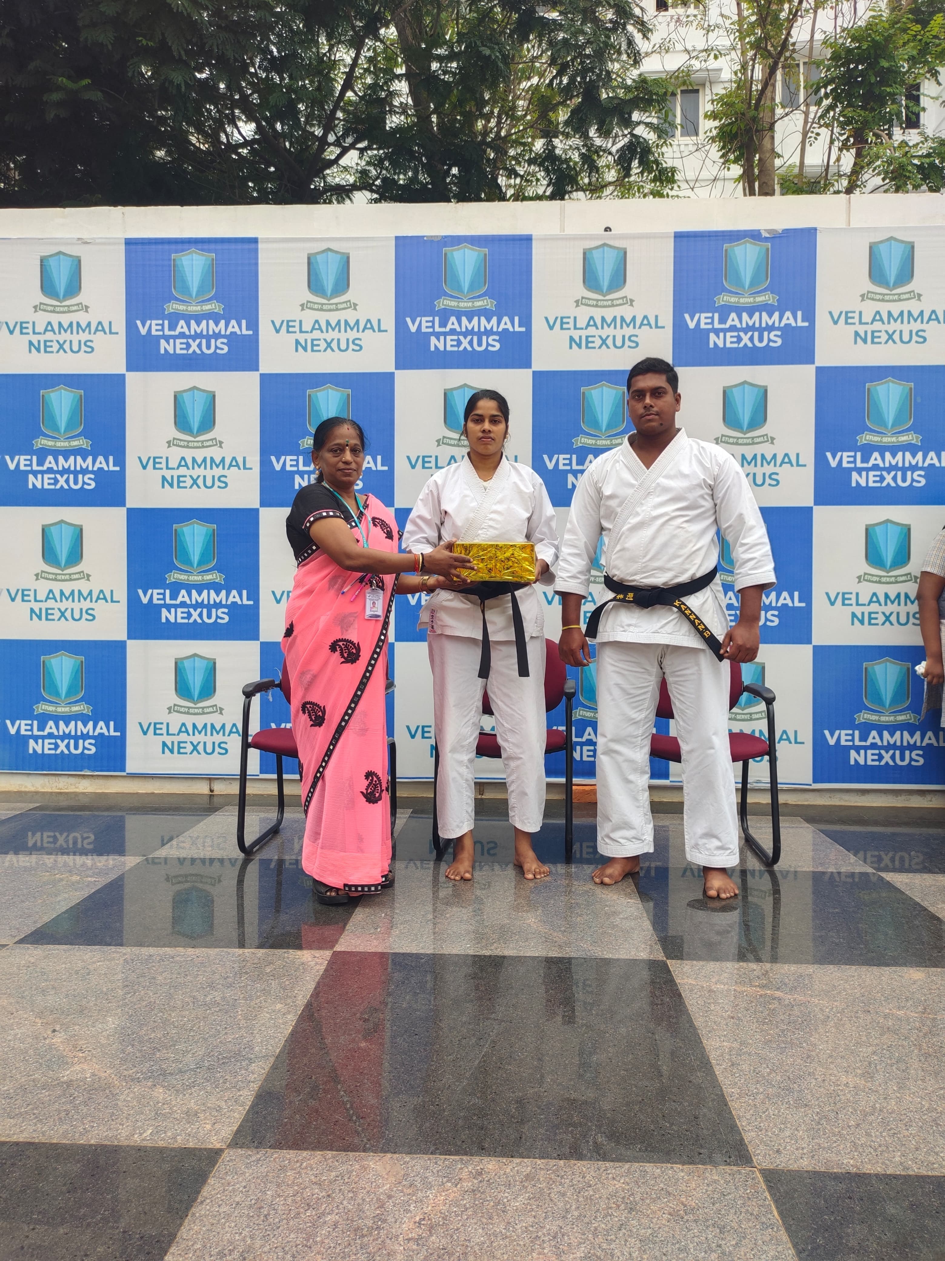 Kannan and Kowsalya receiving an acknowledgement at Velammal Nexus Avadi