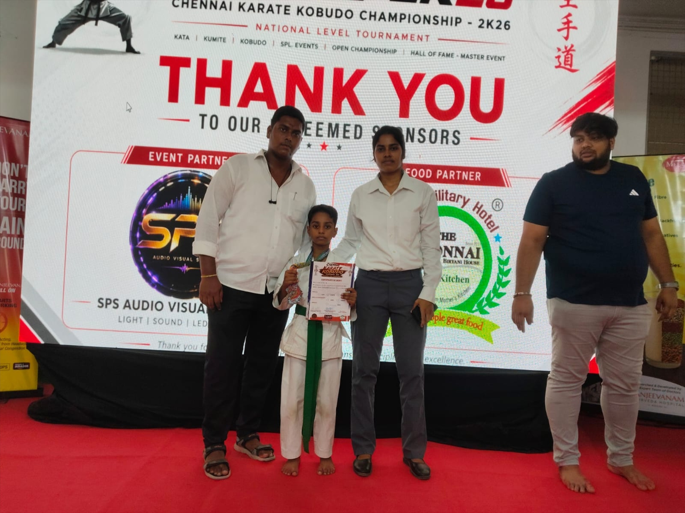 Karate student with medal and certificate alongside instructors at the Chennai national tournament